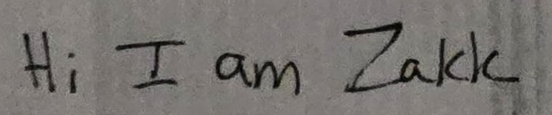 “Hi I am Zakk” handwritten in black pen on white paper.