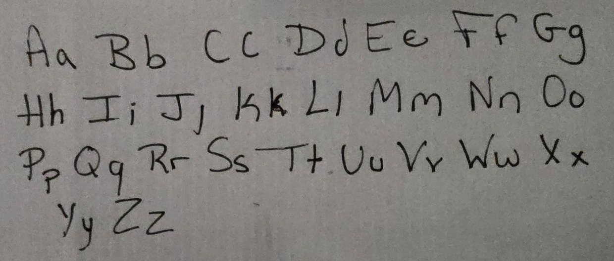 The first sample sheet: the alphabet in capitals and lowercase, handwritten in black pen.