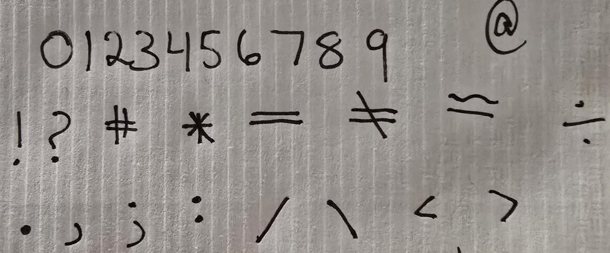 The second sample sheet: the numbers 0 to 9 and symbols, handwritten in black pen.